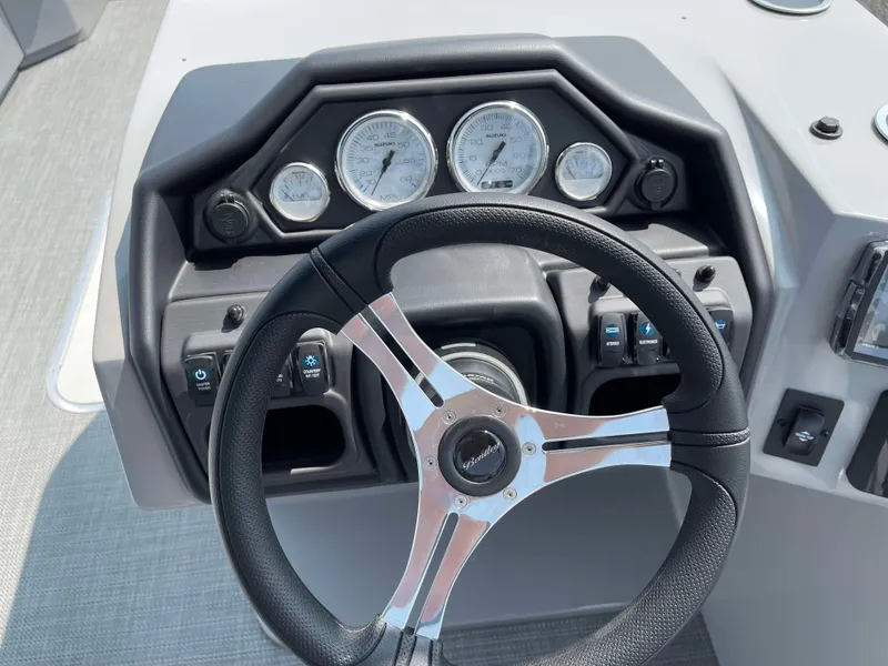 Slide: The Image of 2025 Bentley Pontoons Legacy 243 Swingback dashboard with steering wheel and gauges. - 19