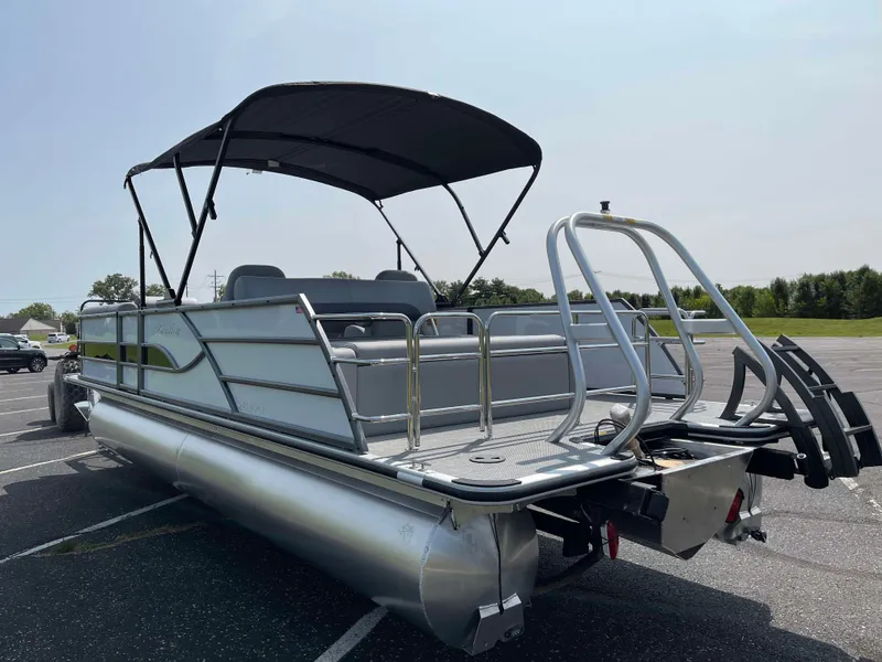 Slide: The Image of 2025 Bentley Pontoons Legacy 243 Swingback pontoon boat with canopy in parking lot. - 2
