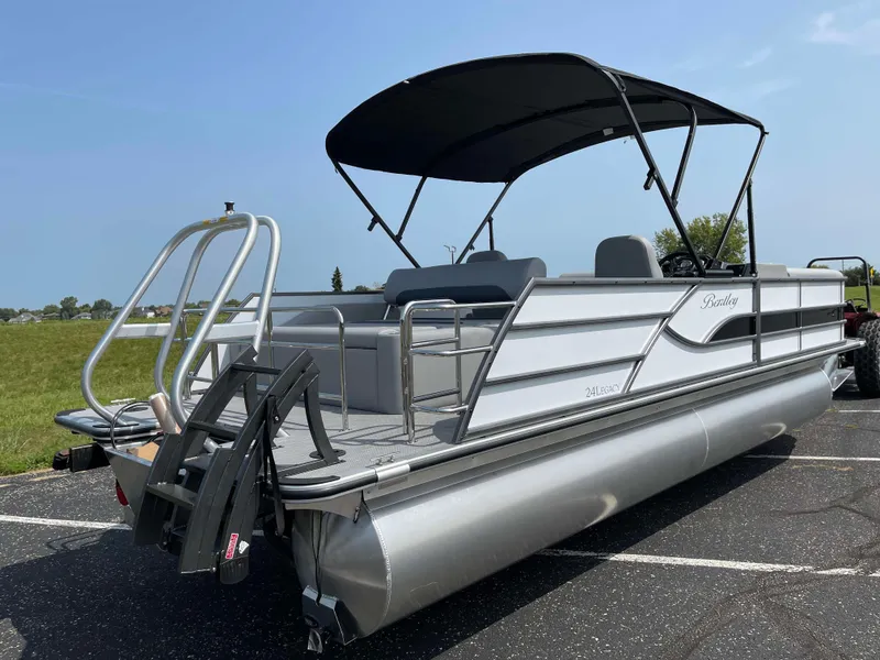 Slide: The Image of 2025 Bentley Pontoons Legacy 243 Swingback pontoon boat with canopy, parked on asphalt. - 4