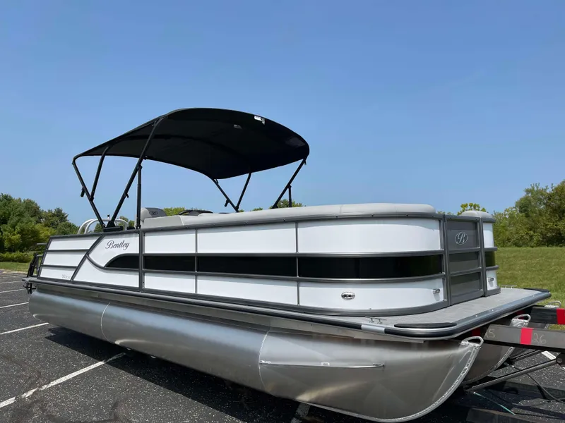 Slide: The Image of 2025 Bentley Pontoons Legacy 243 Swingback pontoon boat with canopy in a parking lot. - 6