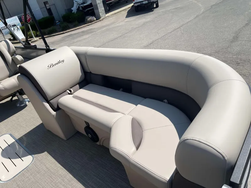 Slide: The Image of 2025 Bentley Pontoons Legacy 223 QSB interior seating, beige upholstery, outdoor setting. - 10
