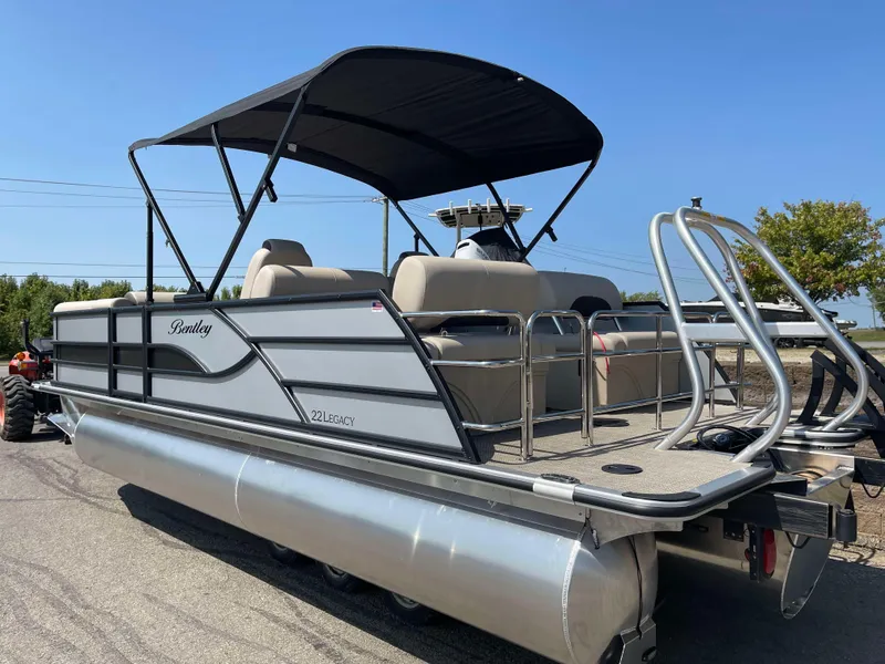 Slide: The Image of 2025 Bentley Pontoons Legacy 223 QSB pontoon boat with canopy, parked on a sunny day. - 5