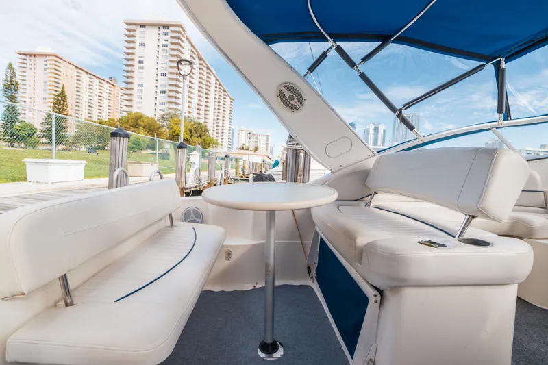 Slide: The Image of Interior of 2005 Bayliner 285 boat with white seating and blue canopy. - 10