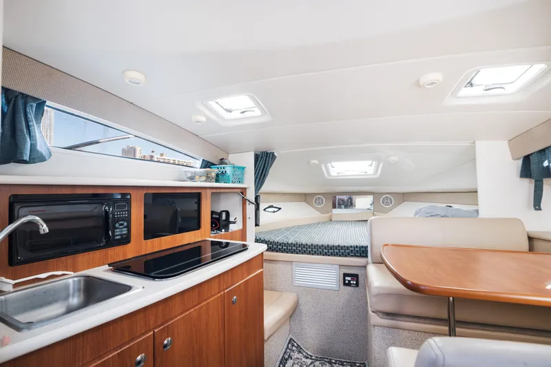 Slide: The Image of Interior of 2005 Bayliner 285 boat with kitchenette and seating area. - 13