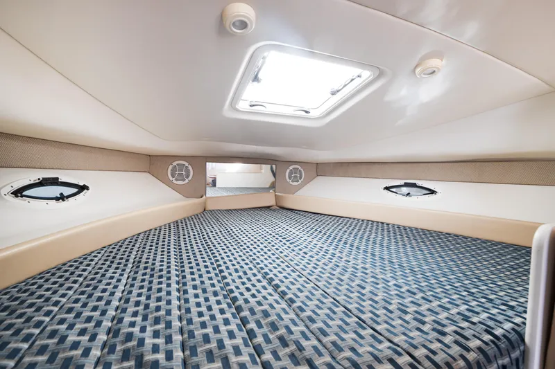 Slide: The Image of Interior cabin of 2005 Bayliner 285 boat with patterned bedding and portholes. - 15
