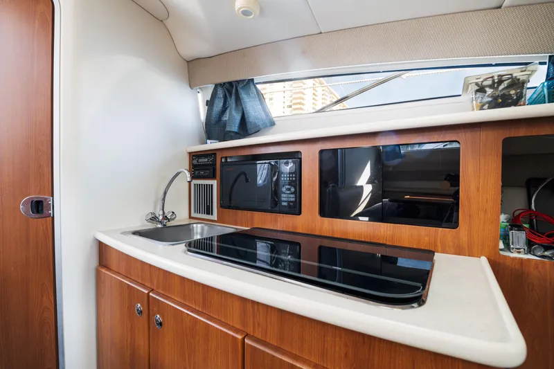 Slide: The Image of 2005 Bayliner 285 boat interior kitchen with sink, stove, and microwave. - 16