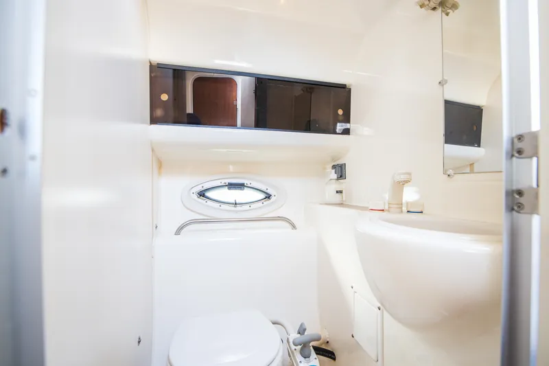 Slide: The Image of 2005 Bayliner 285 boat bathroom with modern fixtures and storage cabinets. - 18