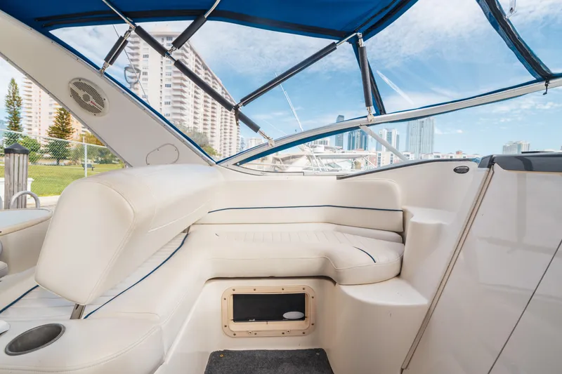 Slide: The Image of Interior of 2005 Bayliner 285 boat with white seating and blue canopy. - 8