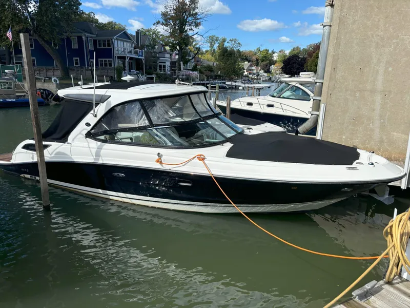 Slide: The Image of 2016 Sea Ray 350 SLX boat docked in a marina, featuring sleek design and black hull. - 0