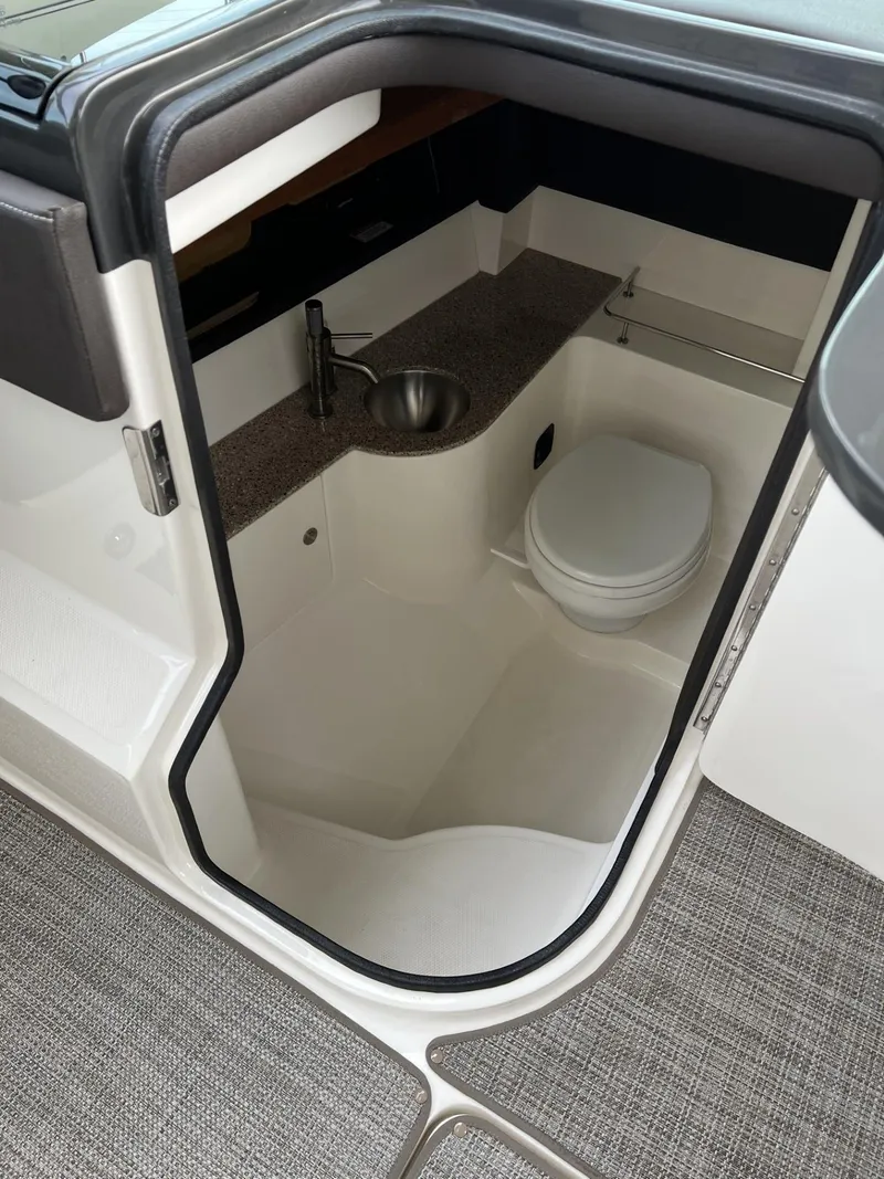 Slide: The Image of 2016 Sea Ray 350 SLX boat interior with compact bathroom and sink. - 14
