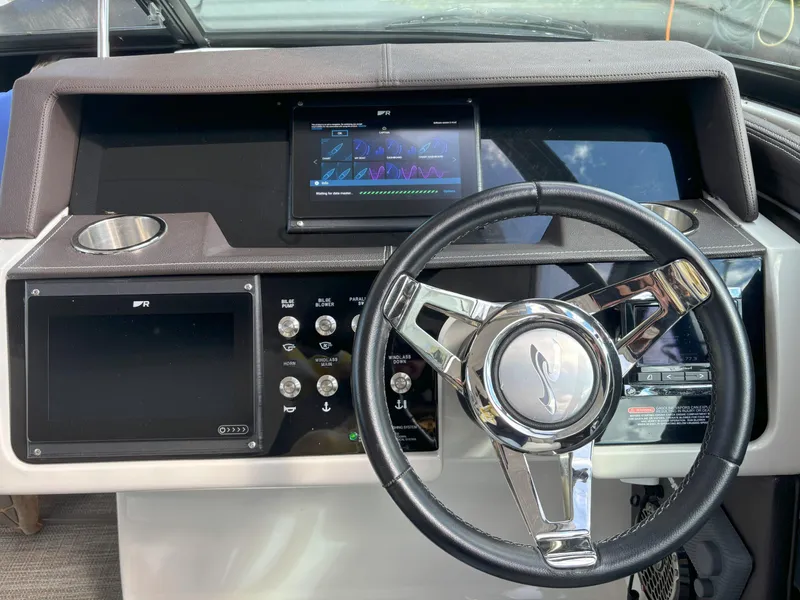 Slide: The Image of 2016 Sea Ray 350 SLX boat dashboard with steering wheel and digital displays. - 2