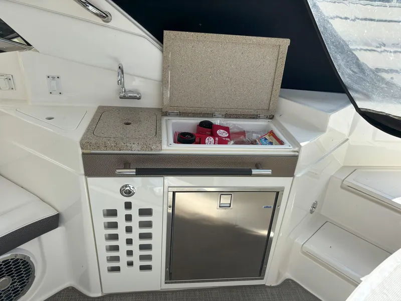 Slide: The Image of 2016 Sea Ray 350 SLX boat interior with kitchenette and mini fridge. - 24