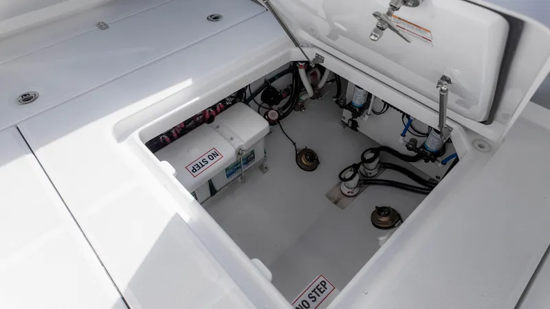 Slide: The Image of 2025 Everglades 315 Center Console boat storage compartment with visible equipment and "No Step" warning. - 14