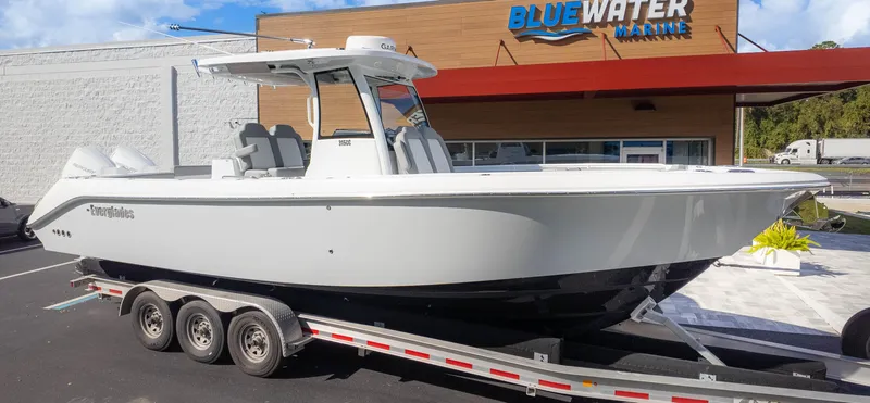 Slide: The Image of 2025 Everglades 315 Center Console boat on trailer at Bluewater Marine dealership. - 2