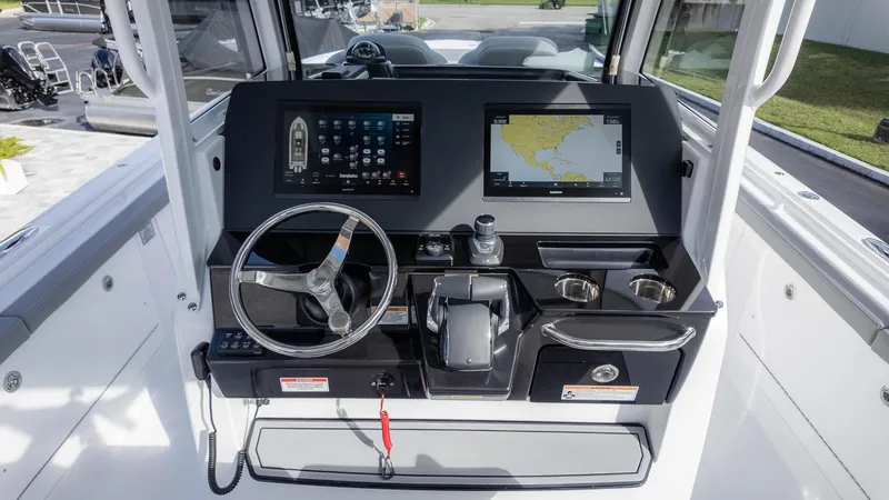 Slide: The Image of 2025 Everglades 315 Center Console boat dashboard with navigation screens and steering wheel. - 21