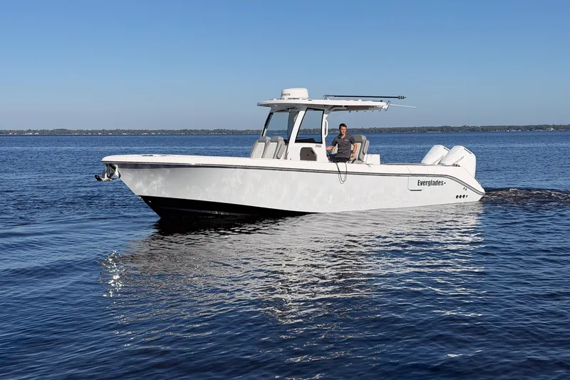 Slide: The Image of 2025 Everglades 315 Center Console boat cruising on calm blue waters. - 42