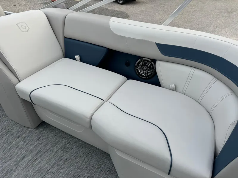 Slide: The Image of 2025 Sweetwater 2286 SB boat interior seating with speaker, featuring sleek white and blue design. - 10