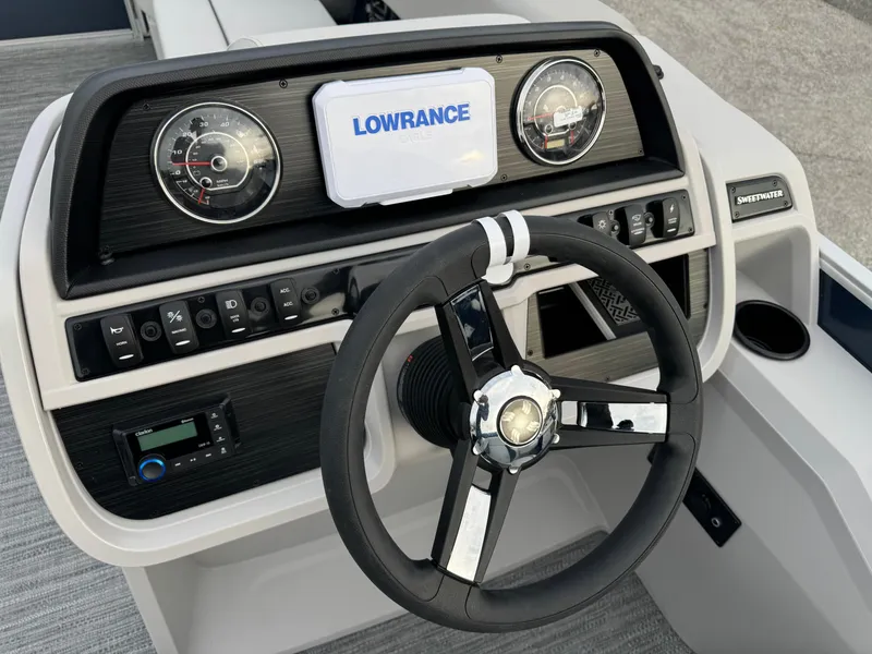Slide: The Image of Sweetwater 2286 SB 2025 boat dashboard with steering wheel and Lowrance display. - 5