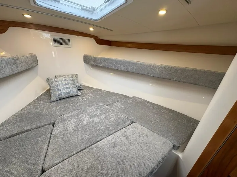 Slide: The Image of 2025 Albemarle 30 Express cabin interior with gray cushions and overhead lighting. - 18