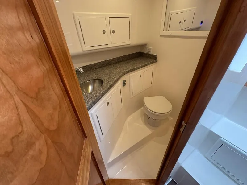 Slide: The Image of 2025 Albemarle 30 Express boat bathroom with sink, toilet, and storage cabinets. - 19