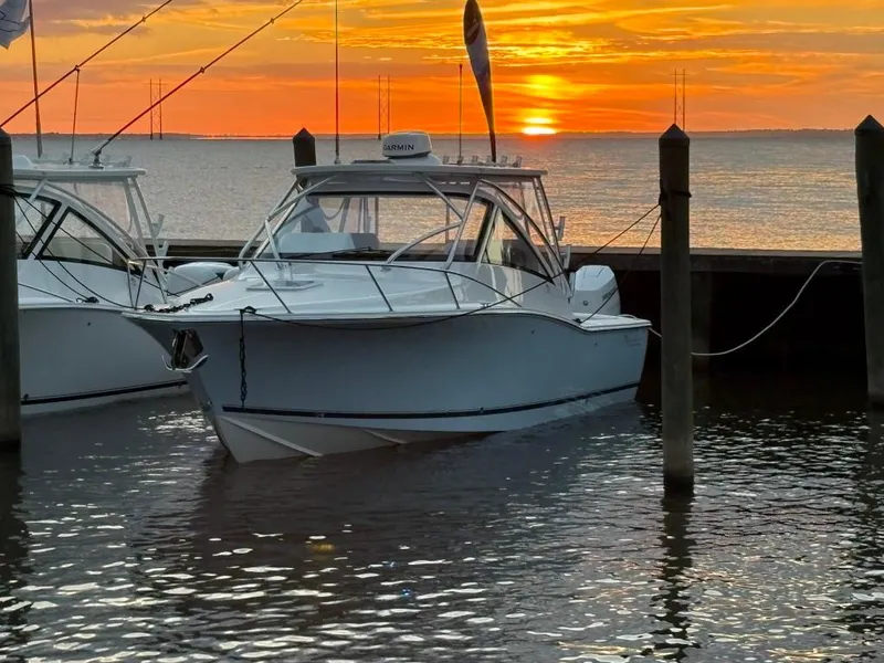 Slide: The Image of 2025 Albemarle 30 Express boat docked at sunset, calm waters reflecting vibrant sky. - 2