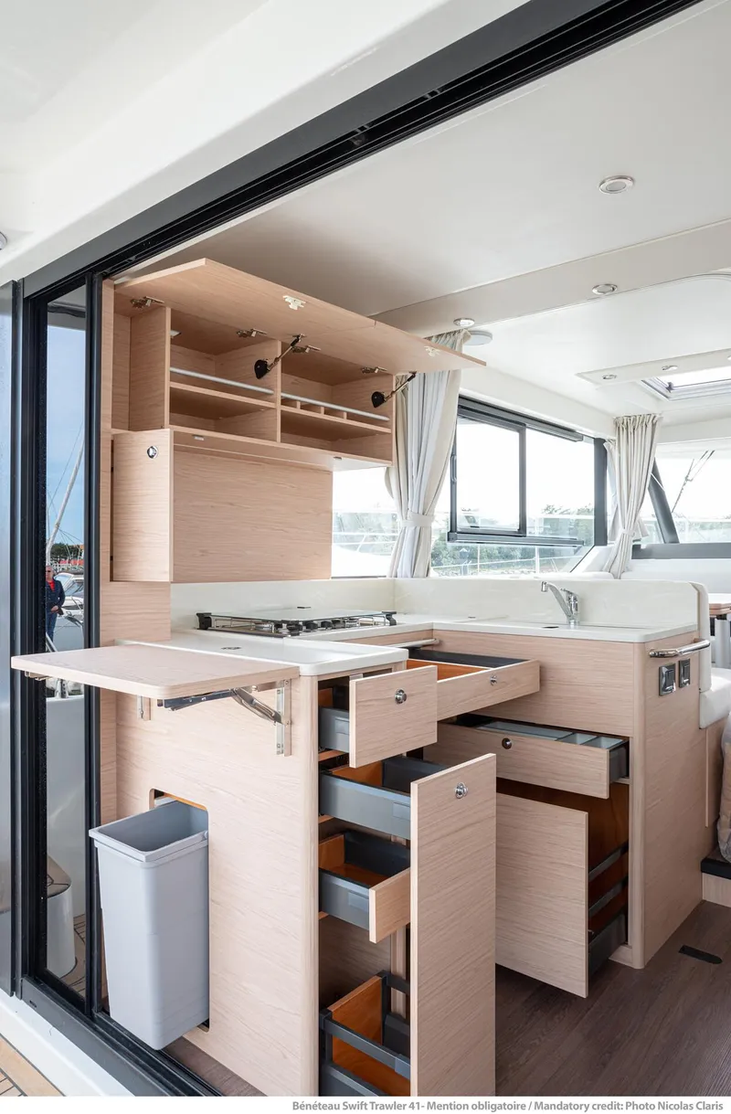 Slide: The Image of 2024 Beneteau Swift Trawler 41 interior kitchen with modern cabinetry and open layout. - 21