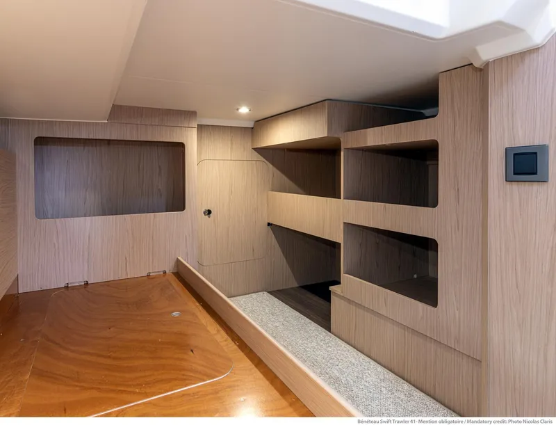 Slide: The Image of 2024 Beneteau Swift Trawler 41 interior cabin with modern wood finish and shelving. - 28