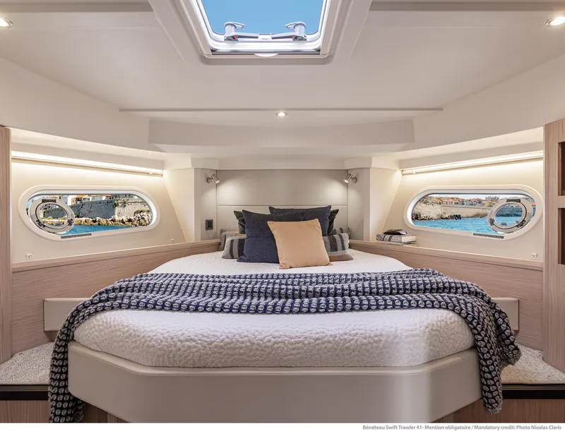 Slide: The Image of Luxurious 2024 Beneteau Swift Trawler 41 cabin with elegant bedding and scenic windows. - 29