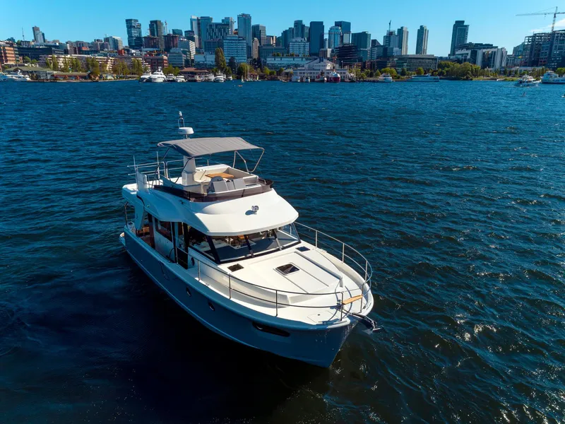 Slide: The Image of 2024 Beneteau Swift Trawler 41 cruising near city skyline on a sunny day. - 4