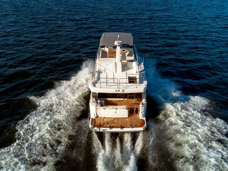 Slide: The Image of 2024 Beneteau Swift Trawler 41 cruising on open water, rear view. - 6