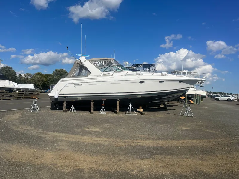 Slide: The Image of 1998 Formula 41PC yacht on stands under a clear blue sky. - 12