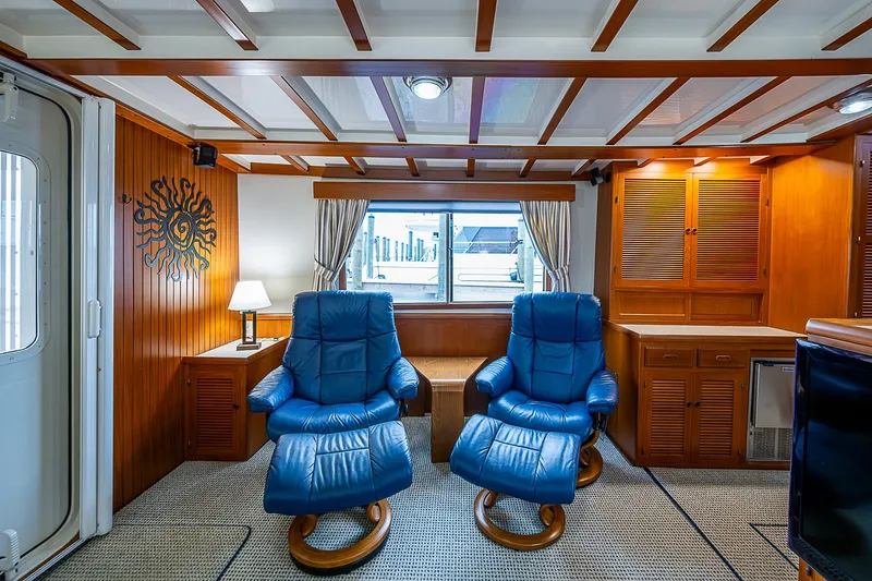 Slide: The Image of Luxurious 2004 Kadey-Krogen North Sea yacht interior with blue recliners and wooden cabinetry. - 10