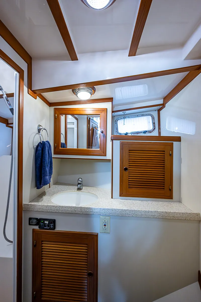 Slide: The Image of 2004 Kadey-Krogen North Sea yacht bathroom with wooden cabinets and modern fixtures. - 25