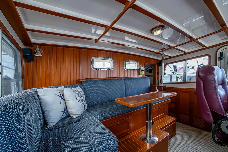 Slide: The Image of 2004 Kadey-Krogen Krogen North Sea interior with blue seating, wooden accents, and nautical decor. - 31