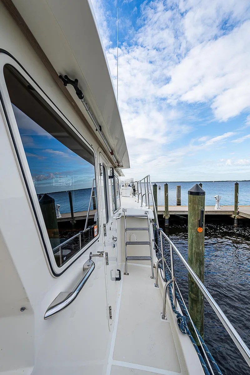 Slide: The Image of 2004 Kadey-Krogen Krogen North Sea yacht docked by the water under a blue sky. - 41