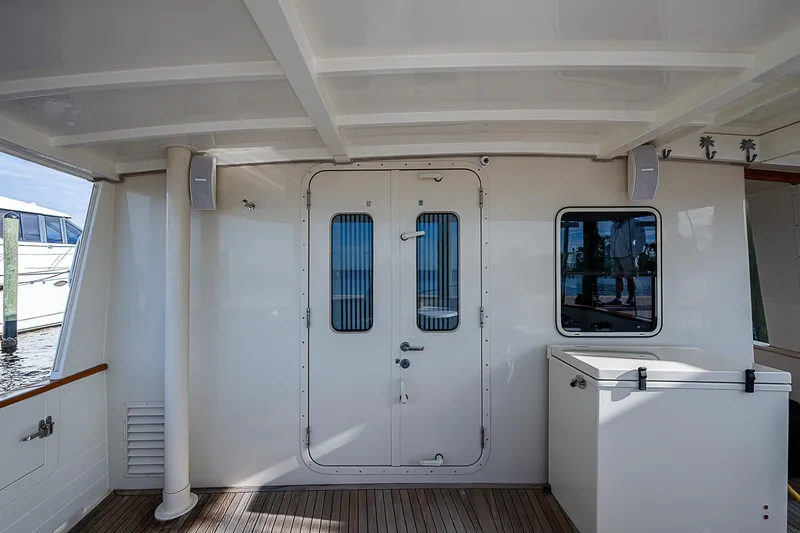 Slide: The Image of 2004 Kadey-Krogen Krogen North Sea yacht deck with door and window, featuring wooden flooring. - 6