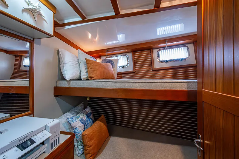 Slide: The Image of 2004 Kadey-Krogen Krogen North Sea cabin with cozy bed, wooden accents, and porthole windows. - 18