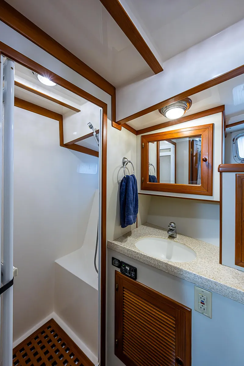 Slide: The Image of 2004 Kadey-Krogen Krogen North Sea yacht bathroom with shower, sink, and wooden accents. - 27