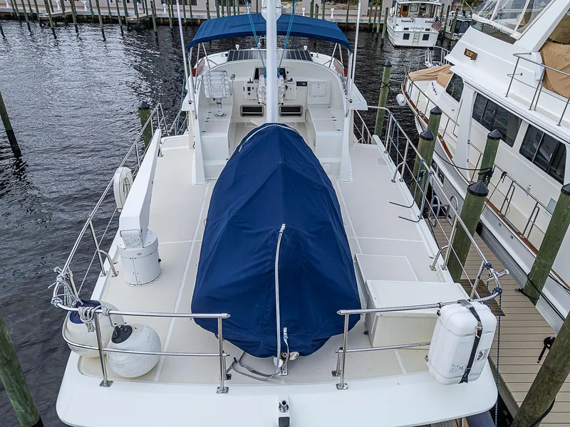 Slide: The Image of 2004 Kadey-Krogen Krogen North Sea yacht docked, featuring spacious deck and blue canopy. - 46