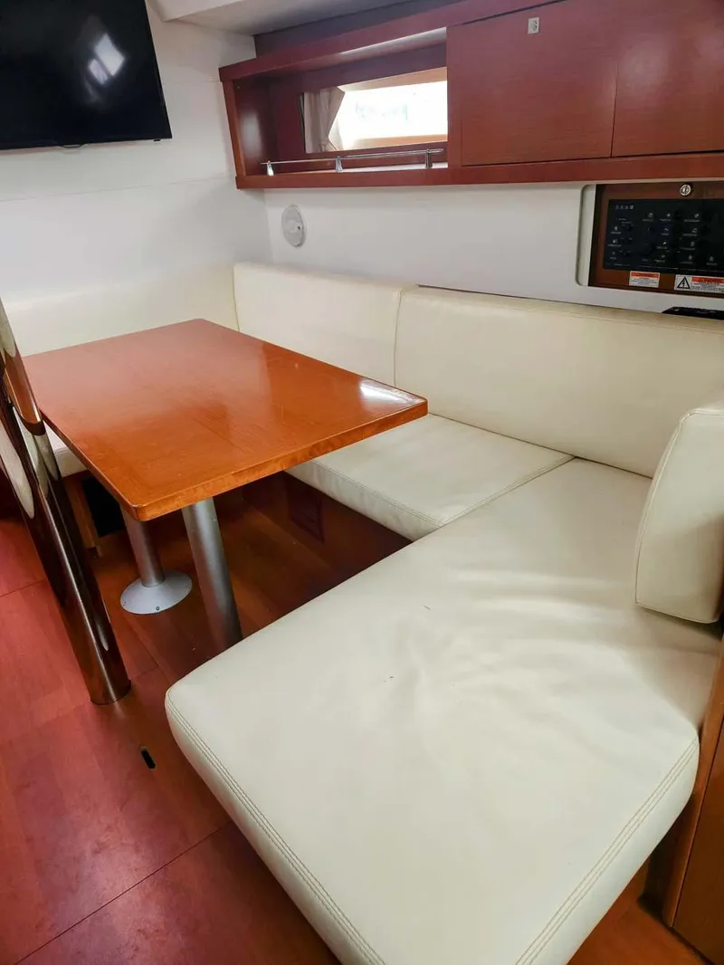 Slide: The Image of Interior of 2012 Beneteau Oceanis 41 yacht with white seating and wooden table. - 17