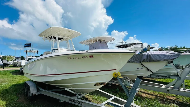 Slide: The Image of 2018 Boston Whaler 230 Outrage boat on trailer under blue sky. - 10