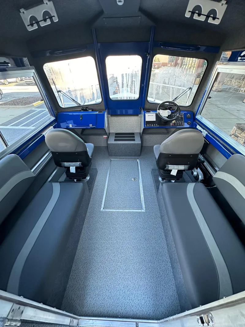 Slide: The Image of Interior of 2025 Spartan 240 Maximus Pro boat with seating and steering console. - 11