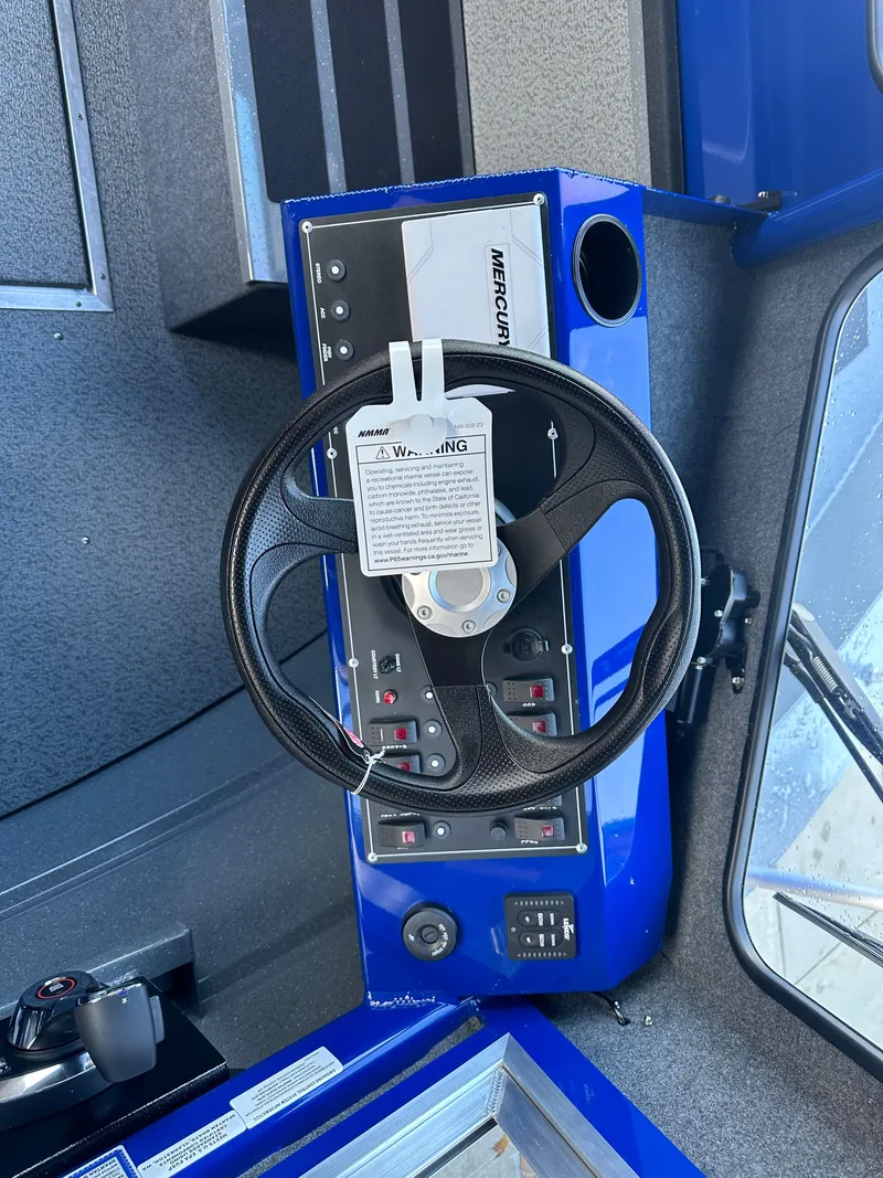 Slide: The Image of 2025 Spartan 240 Maximus Pro boat dashboard with steering wheel and controls. - 14