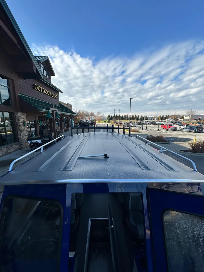 Slide: The Image of 2025 Spartan 240 Maximus Pro parked outside a store under a partly cloudy sky. - 19