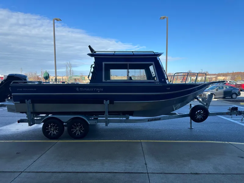 Slide: The Image of 2025 Spartan 240 Maximus Pro boat on trailer, parked outdoors under blue sky. - 3