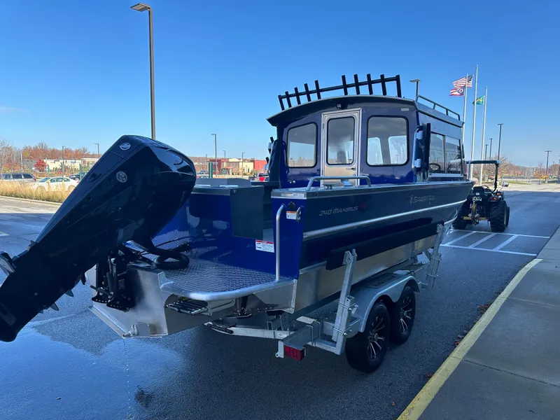 Slide: The Image of 2025 Spartan 240 Maximus Pro boat on trailer, blue exterior, parked outdoors. - 4