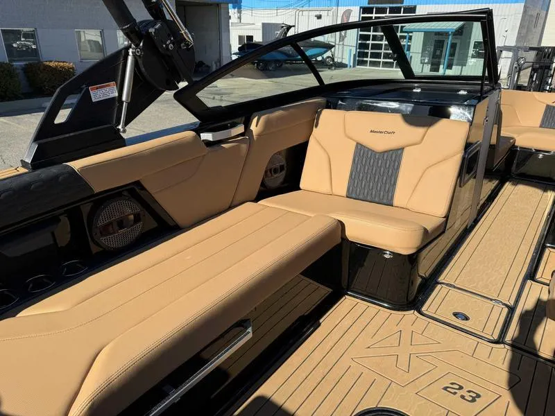 Slide: The Image of 2024 MasterCraft XT23 boat interior with tan leather seats and modern design. - 10