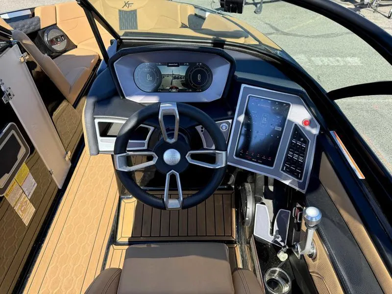 Slide: The Image of 2024 MasterCraft XT23 boat dashboard with modern steering wheel and digital controls. - 11