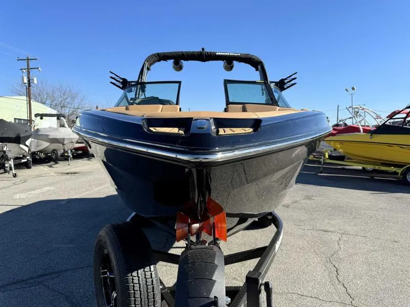 Slide: The Image of 2024 MasterCraft XT23 boat on trailer, front view under clear blue sky. - 3
