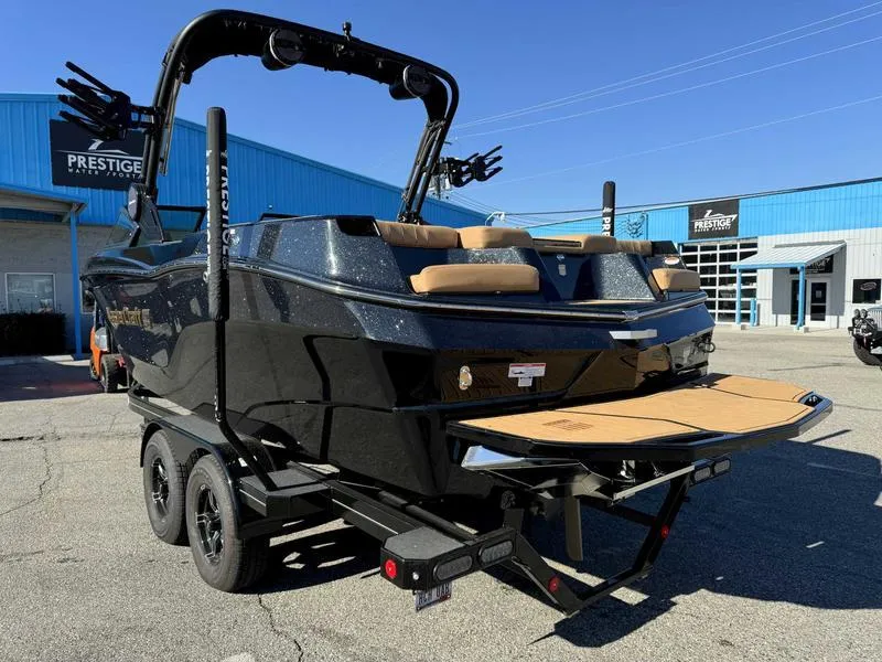 Slide: The Image of 2024 MasterCraft XT23 boat on trailer, black exterior, parked at dealership. - 5
